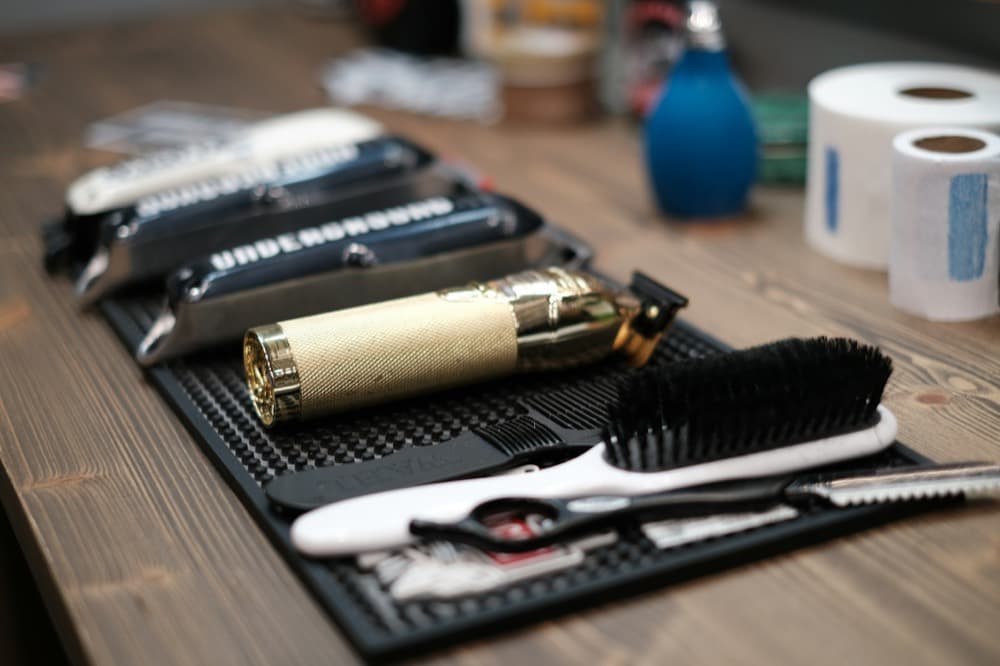 A trimmer, comb and brush on a barber's station