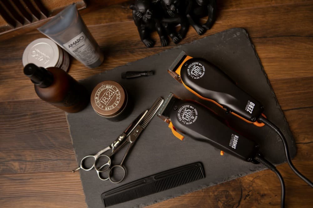 Clippers, scissors and a comb arranged on a slate board